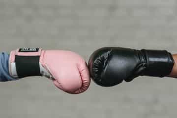 duas pessoas dando as mãos com luvas de boxe