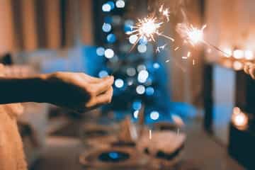 duas pessoas segurando uma vela de aniversário
