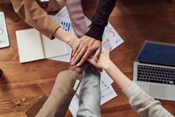 pessoas de um grupo de trabalho dando as mãos